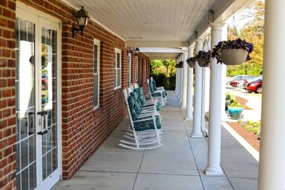 Outdoor rocking chairs lined along a corridor
