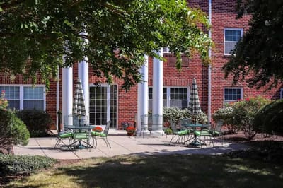 Outdoor seating area with green chairs and landscaping