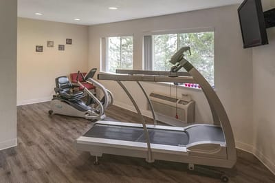 Interior fitness room with treadmill and recumbent bike