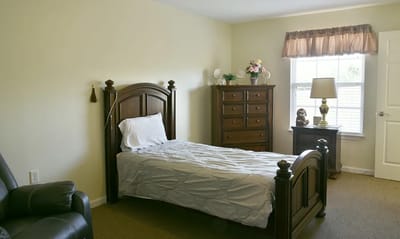Cozy private resident room with a bed and furniture