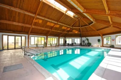 Indoor pool area with wooden ceiling and natural light
