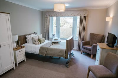 Cozy private resident room with a bed and armchair