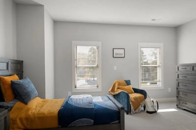 Bright and welcoming resident room with a bed and chair