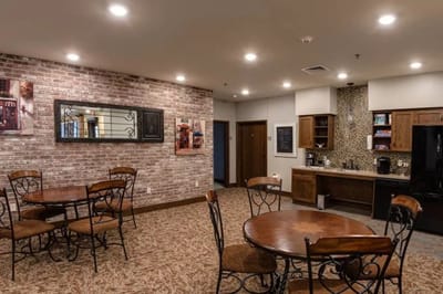 Interior view of a common area with tables and kitchen