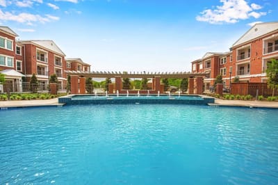 Outdoor swimming pool surrounded by red brick buildings