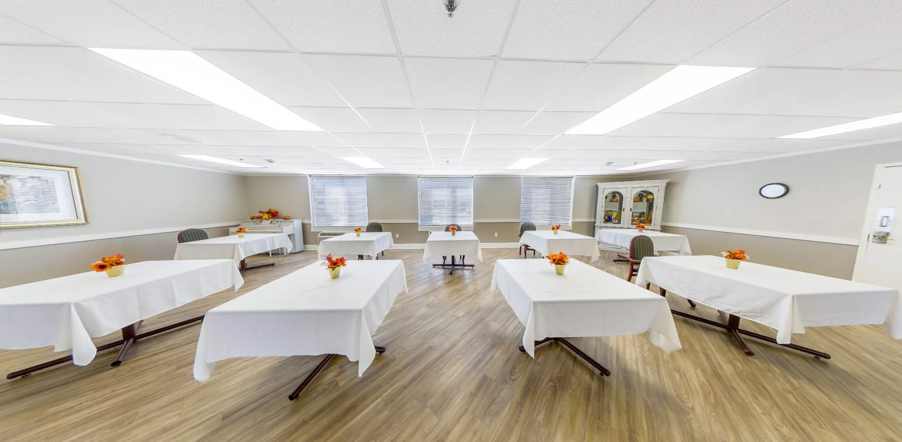 Interior of an activity room with tables and flowers