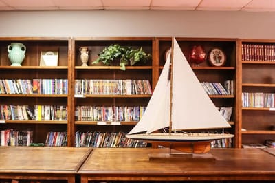 A wooden sailboat displayed in a library area