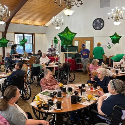 Residents enjoying a meal in a common dining area with festive decor