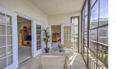 Bright sunroom with seating and view into the living room