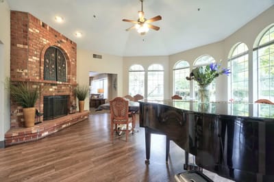 Bright common area with a piano and large windows