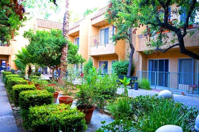 Lush courtyard of a senior living facility with residents