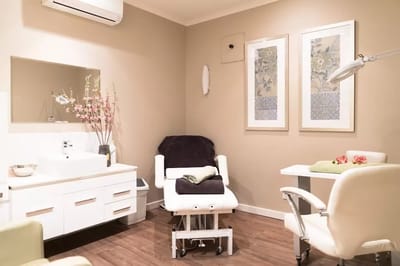 Well-lit treatment room with massage table and decor