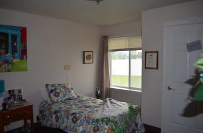 A cozy resident room with a bed and window