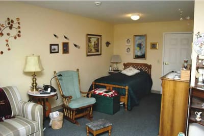 Cozy private room with bed and chair.