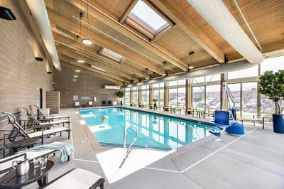 Indoor swimming pool with lounge seating and natural light