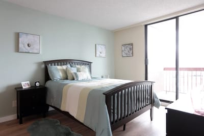Cozy resident room with a bed and balcony access
