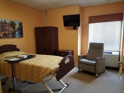 A private resident room with a bed and chair