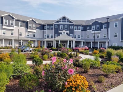 Exterior view of River Mills Assisted Living with gardens