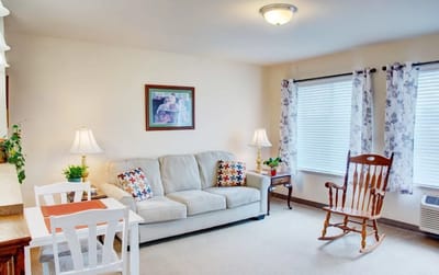 Cozy interior of a resident's room with a sofa and rocking chair