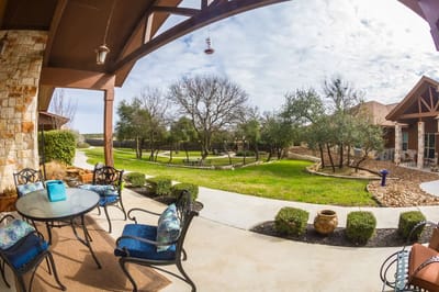 View of outdoor seating area with landscaped garden