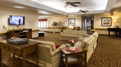 Common area with seating and television in a senior living facility