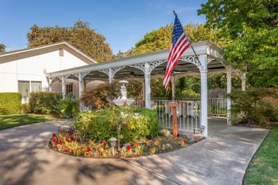 Outdoor area with gazebo, flowers, and American flag