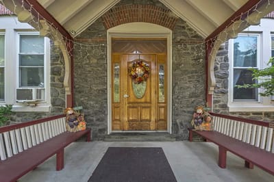 Welcoming entrance with a decorative wreath and seating