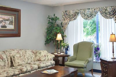 Cozy common area with floral couch and armchair