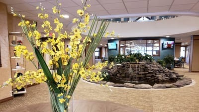 Bright common area with a decorative flower arrangement and water feature