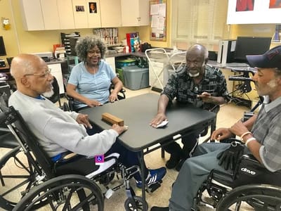 Residents engaged in a game at a common area table