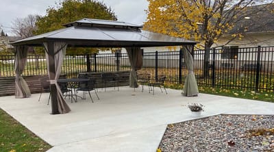 Outdoor gazebo space with seating and landscaping