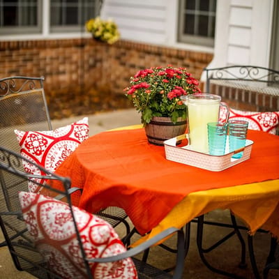 Outdoor table set with lemonade and flowers.