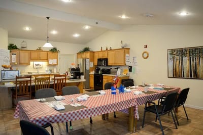 Interior dining area with checkered tablecloths and kitchen