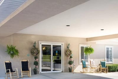 Exterior entrance with rocking chairs and planters