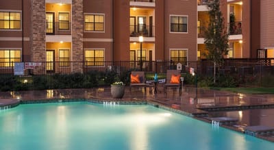 Swimming pool area with lounge chairs and building exterior