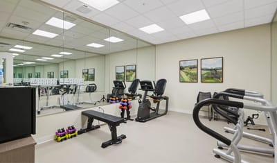 Fitness room with equipment and mirrors