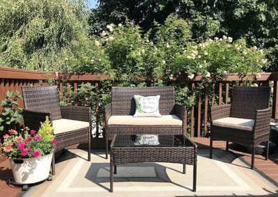 Outdoor seating area with plants and comfortable chairs