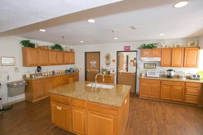 Bright communal kitchen with wooden cabinets and countertops