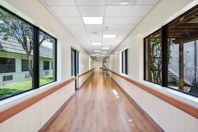 Bright, clean hallway with large windows and wooden floors