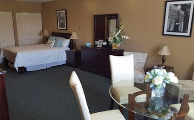 Bright interior of a resident's room with a bed and dining area