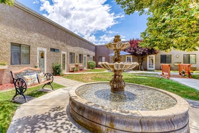 A serene outdoor courtyard with a fountain and benches