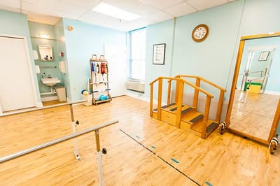 Interior view of a rehabilitation exercise room with a mirror