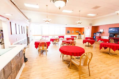 Bright dining area with red tablecloths and chairs
