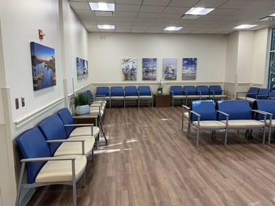 Interior view of a waiting area with chairs and artwork