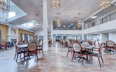 Bright dining area with round tables and chandeliers