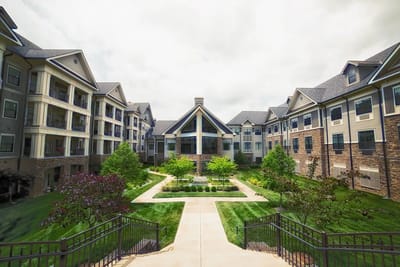 Exterior view of a senior living facility with gardens