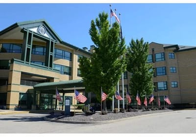 Exterior view of the facility with flags and greenery