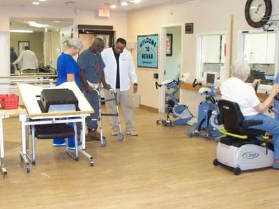 Residents participating in rehabilitation activities with staff assistance