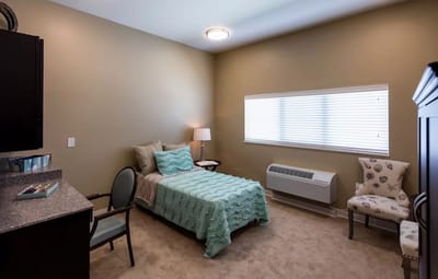 Interior view of a resident room with bed and chair