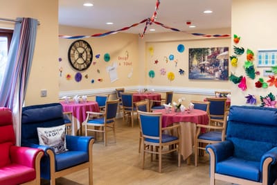 Colorful common area with tables and decorations at St Anne's Care Centre